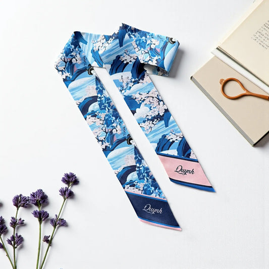 Blue Japanese-inspired twilly scarf featuring cherry blossoms, flowing wave patterns, and personalised name details, displayed on a white background.