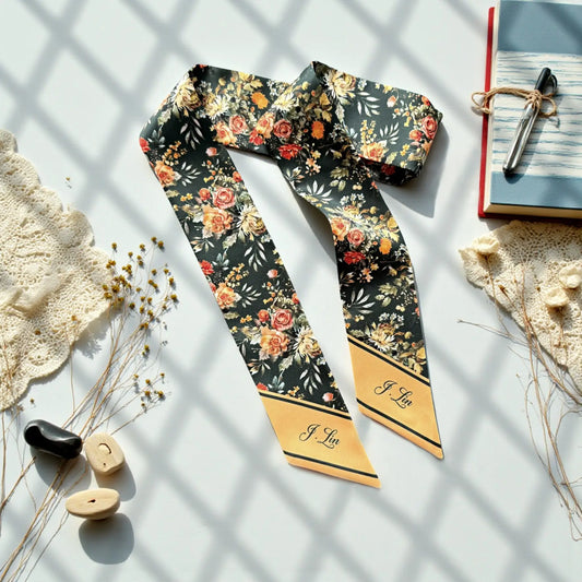 Personalized vintage floral twilly scarf featuring peach and coral roses, golden yellow flowers, and botanical leaves on a dark charcoal background with custom name details.