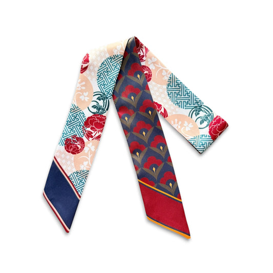 Decorative handbag scarf showcasing red floral motifs, turquoise geometric borders, and soft peach accents against an ivory background.