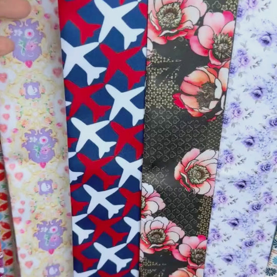Video showing twilly scarf with airplane motif and striped pattern in red, white and blue colours