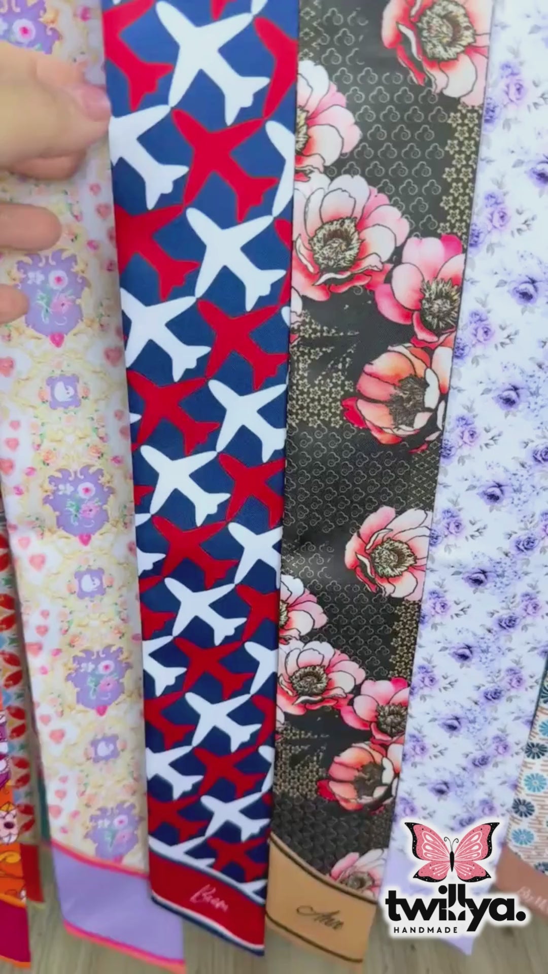 Video showing twilly scarf with airplane motif and striped pattern in red, white and blue colours