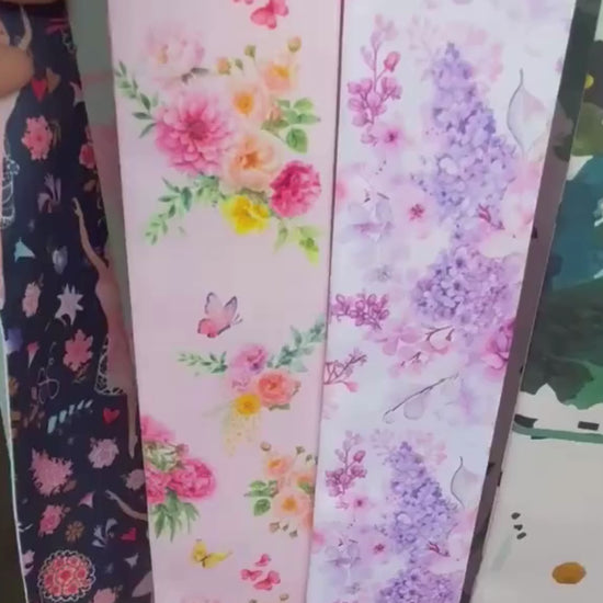 Video showcasing a pink garden floral twilly scarf featuring vibrant blooms, citrus accents, green foliage and delicate butterflies.