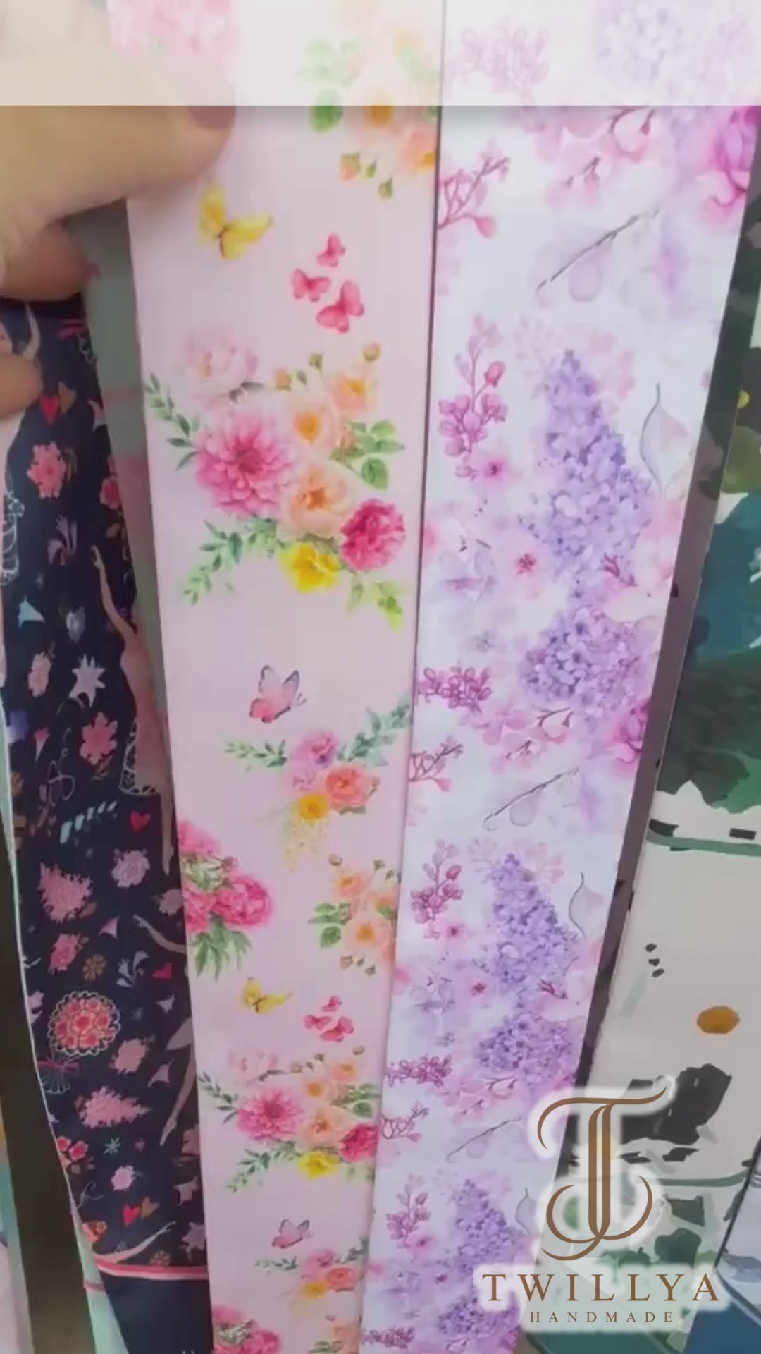 Video showcasing a pink garden floral twilly scarf featuring vibrant blooms, citrus accents, green foliage and delicate butterflies.