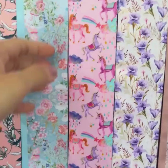 Close-up video showcasing personalised unicorn twilly scarves in pink and navy blue, featuring magical rainbow prints, colourful unicorn illustrations, and custom name details.