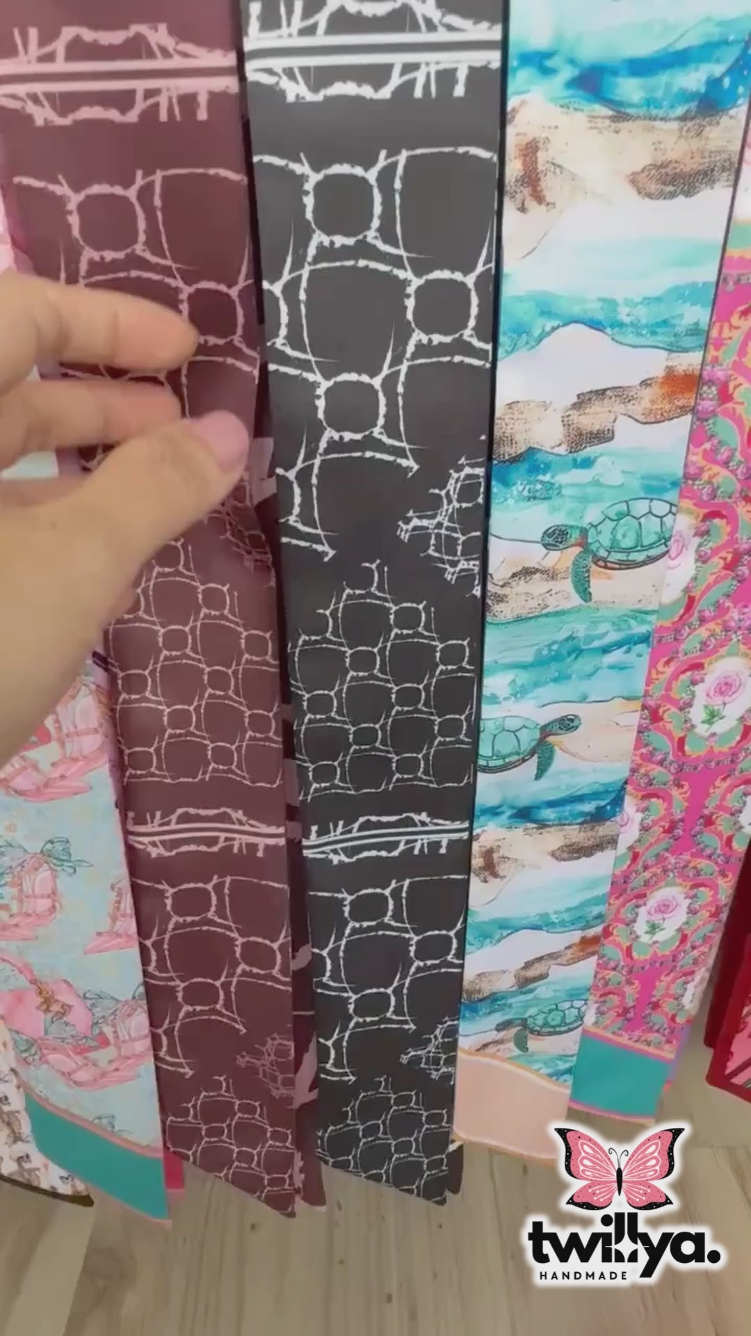 Video of skinny twilly scarf featuring abstract geometric shapes and stripe accents in monochrome color 