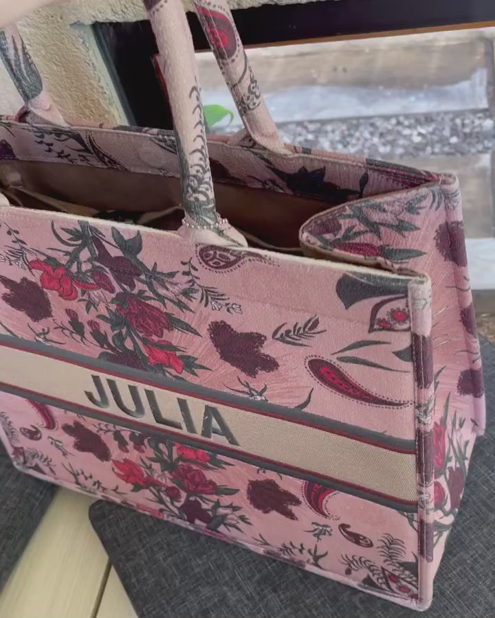 Structured personalized canvas book tote with embroidered name and elegant floral paisley design in blush pink and burgundy tones.