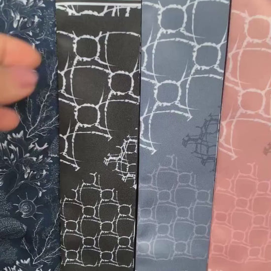 Video showcasing the Alba monochrome twilly scarf collection featuring elegant geometric patterns, bold stripes, and abstract motifs in black, brownish maroon, nude, blue, and green.