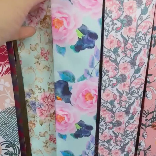 Video showing a watercolour floral twilly scarf with aqua, pink and contrasting navy ornamental patterns