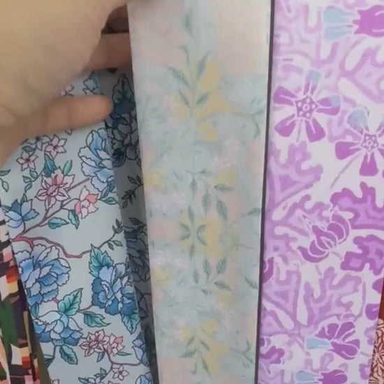 Video showcasing a vintage botanical floral twilly scarf in powder blue, ivory and cream with elegant ornamental patterns.