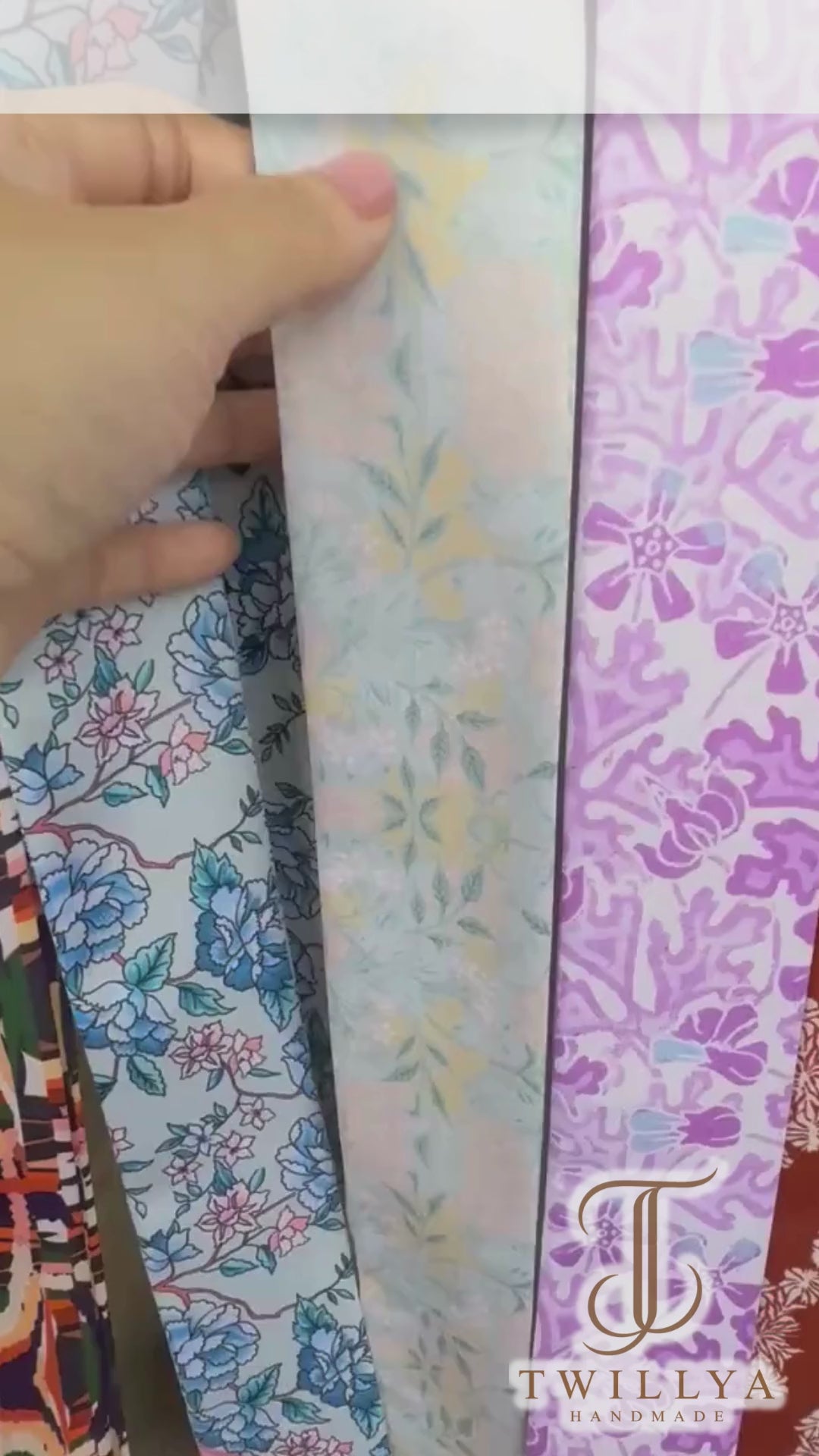 Video showcasing a vintage botanical floral twilly scarf in powder blue, ivory and cream with elegant ornamental patterns.