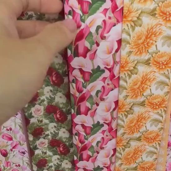 Video showing a calla lily floral twilly scarf with vibrant pink, red, ivory and green botanical motifs and a soft pink contrasting design.