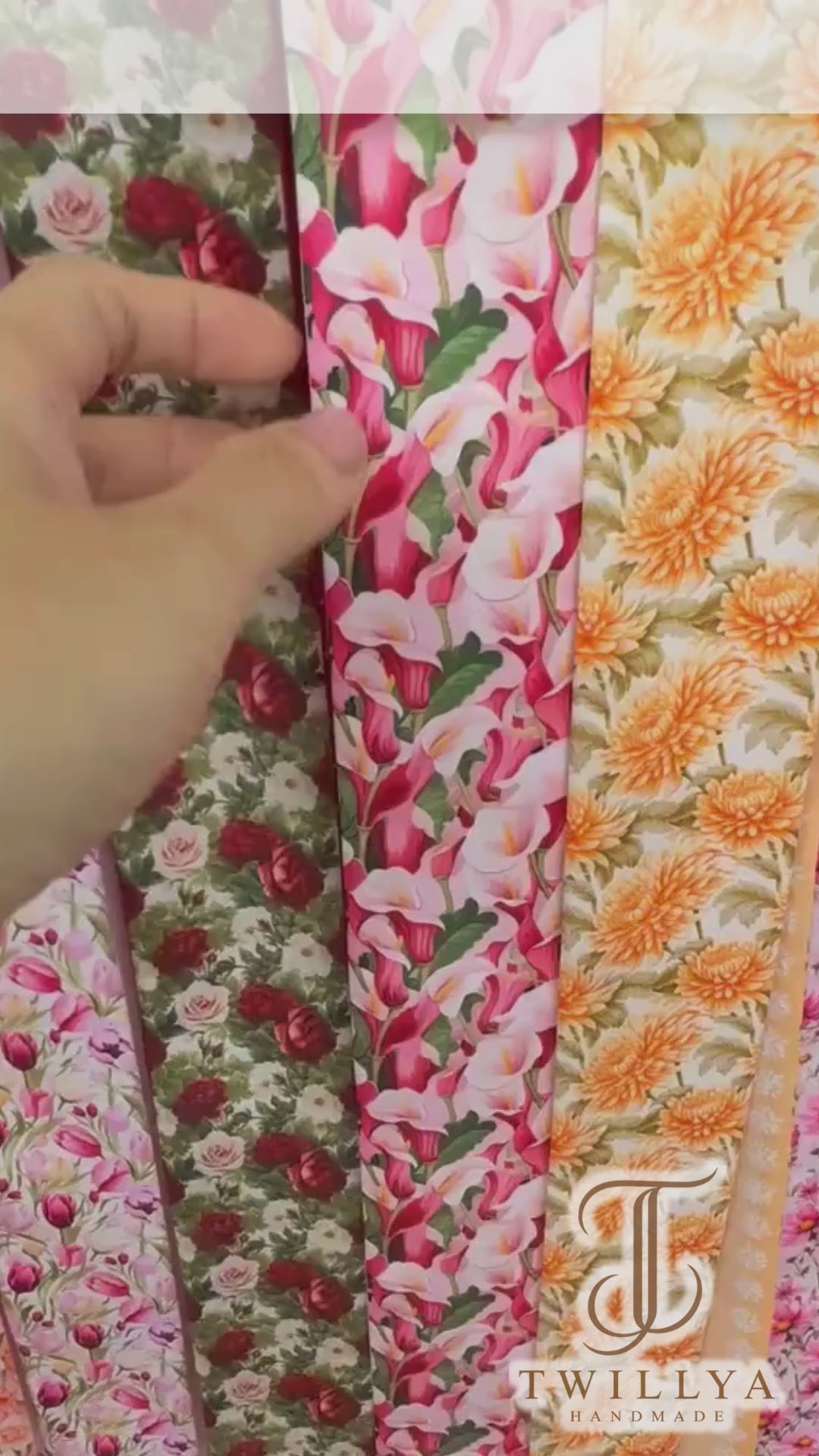 Video showing a calla lily floral twilly scarf with vibrant pink, red, ivory and green botanical motifs and a soft pink contrasting design.