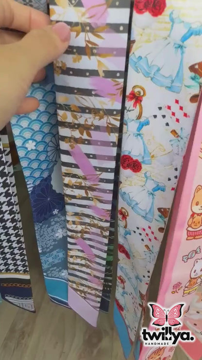 Video showing double-sided twilly scarf with abstract leaf and striped pattern in modern colours