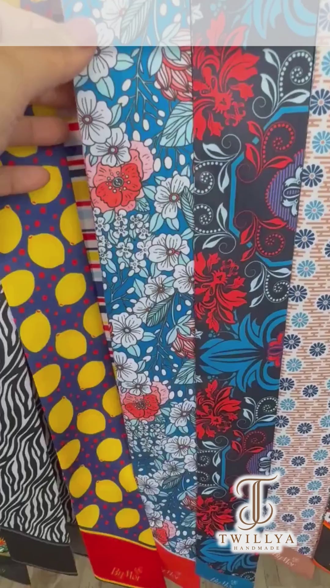 Colourful floral twilly scarf showcasing contrasting coral red and blue botanical patterns, delicate white and pink flowers, and custom name details. A versatile skinny scarf for handbags, hair styling, and personalized gifting.