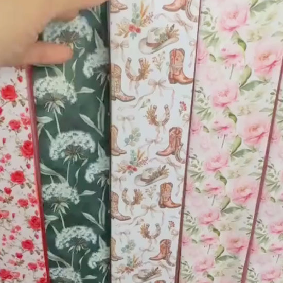 Close-up video of western floral skinny scarf featuring cowgirl boots and hats pattern and blush pink ornamental details