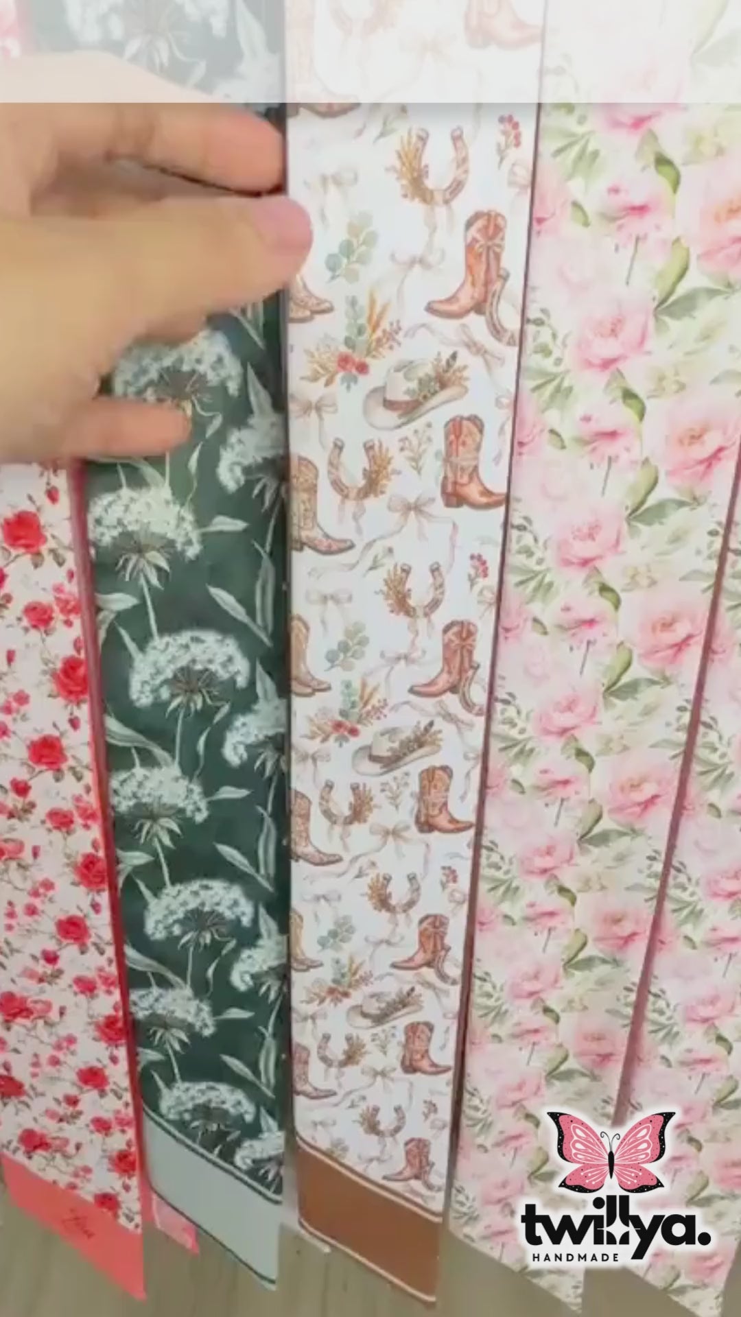 Close-up video of western floral skinny scarf featuring cowgirl boots and hats pattern and blush pink ornamental details