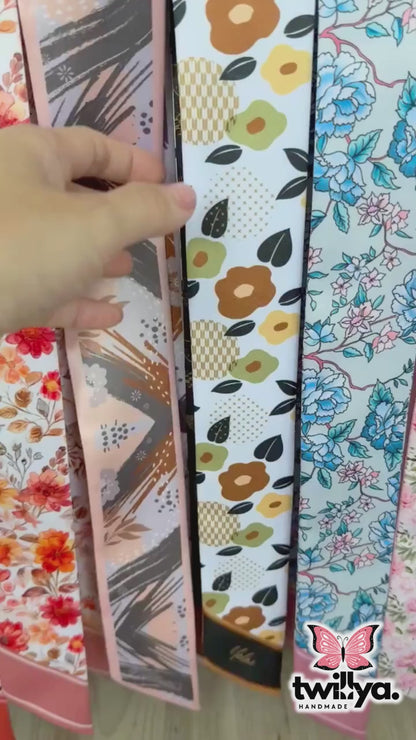 Video showing double-sided twilly scarf with floral and geometric design in brown and orange colors