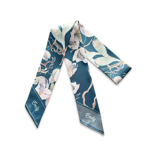 Botanical handbag scarf showcasing watercolor-style ivory blossoms, muted green foliage, and graceful branches against a rich teal background.